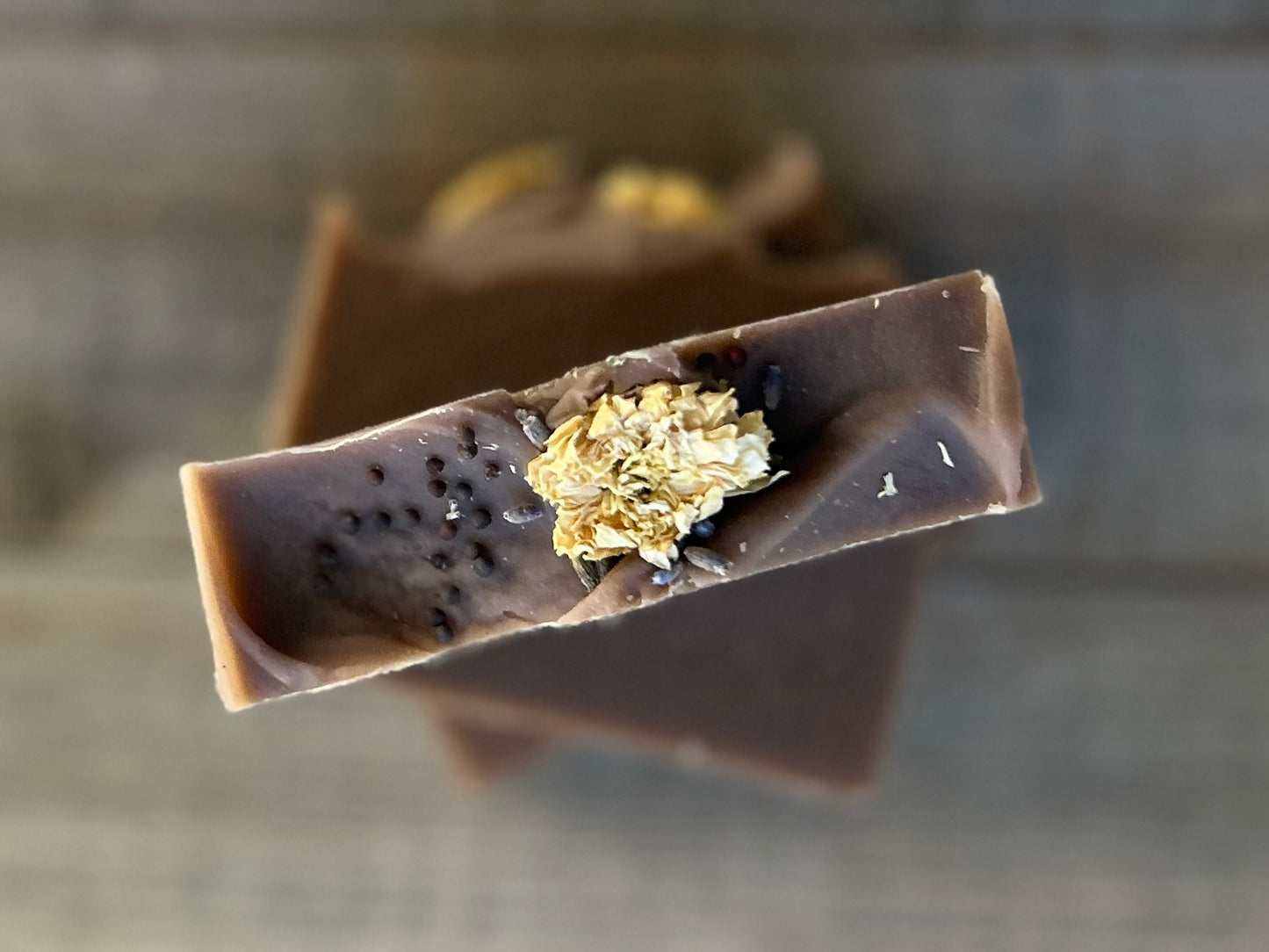 Take a step into the country with Wild Lavender soap. Scented with lavender, patchouli and juniper essential oil and sandalwood powder. It's the perfect blend of rich earthy floral. Made with nourishing goat's milk, olive oil, coconut oil, cocoa butter, avocado oil and castor oil. This soap is naturally colored with purple Brazilian clay and sandalwood powder for light exfoliation. Topped with lavender buds, broccoli seeds and a white chrysanthemum. Kendrick Homestead