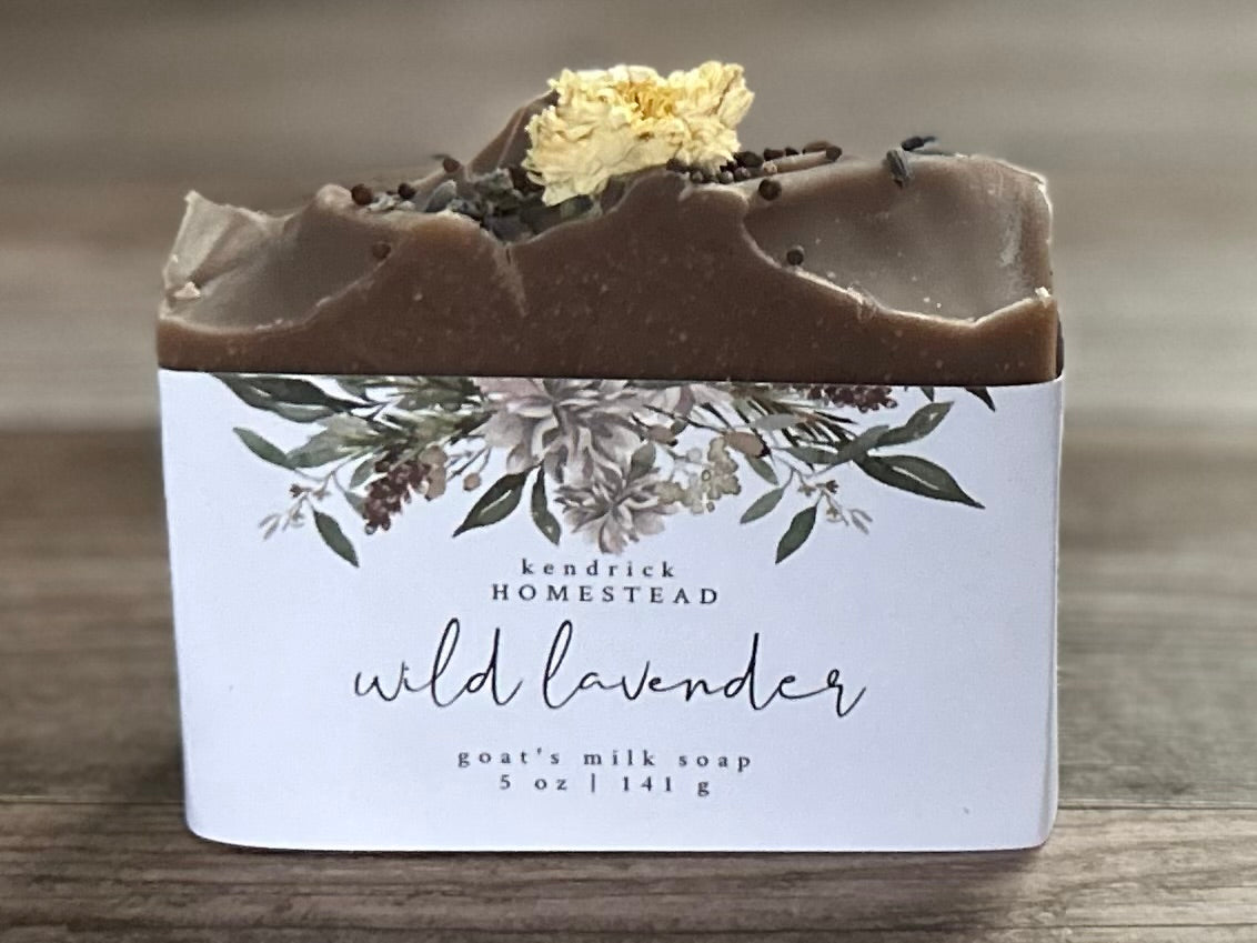 Take a step into the country with Wild Lavender soap. Scented with lavender, patchouli and juniper essential oil and sandalwood powder. It's the perfect blend of rich earthy floral. Made with nourishing goat's milk, olive oil, coconut oil, cocoa butter, avocado oil and castor oil. This soap is naturally colored with purple Brazilian clay and sandalwood powder for light exfoliation. Topped with lavender buds, broccoli seeds and a white chrysanthemum. Kendrick Homestead