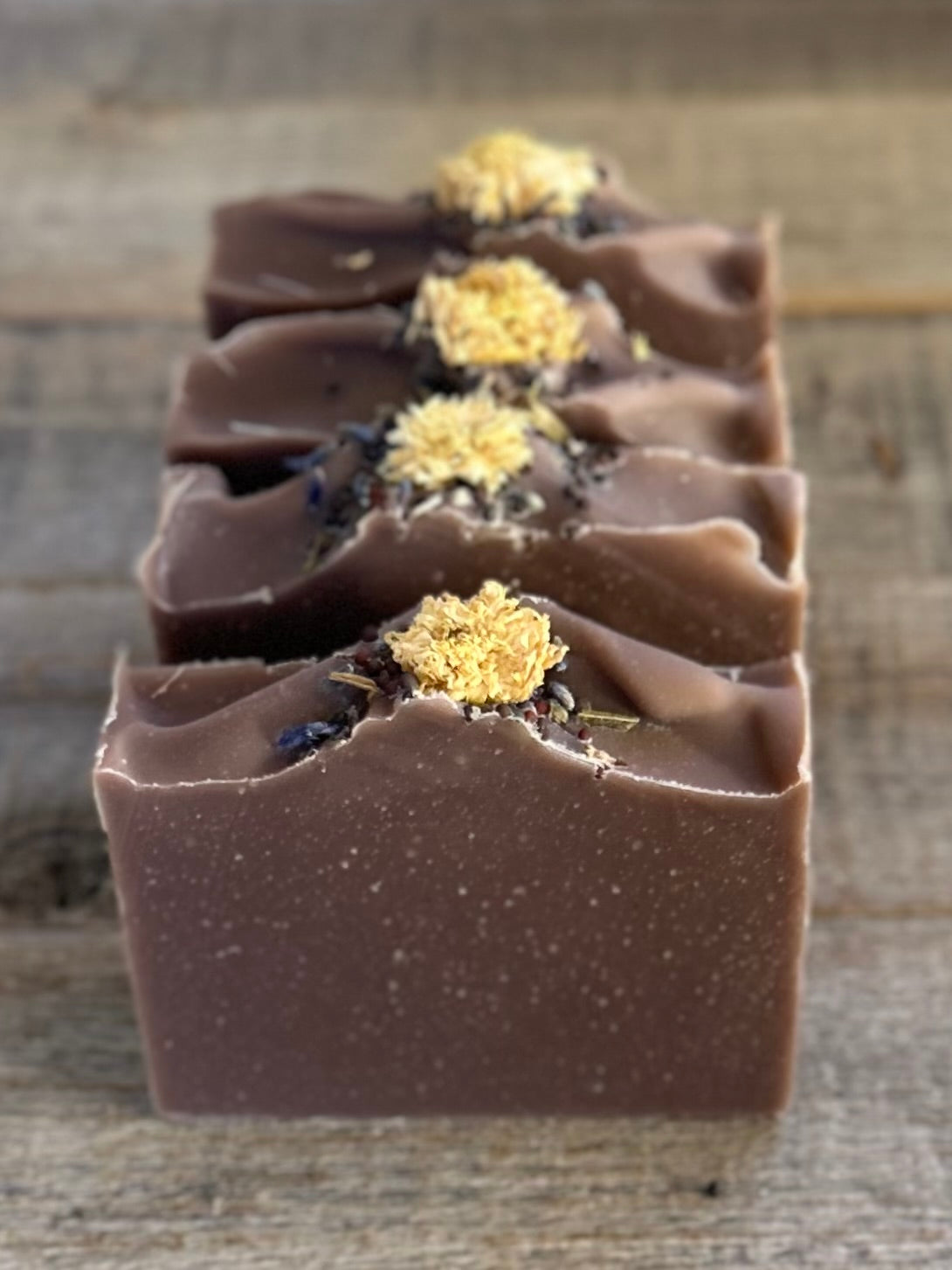 Take a step into the country with Wild Lavender soap. Scented with lavender, patchouli and juniper essential oil and sandalwood powder. It's the perfect blend of rich earthy floral.&nbsp; Made with nourishing goat's milk, olive oil, coconut oil, cocoa butter, avocado oil and castor oil. This soap is naturally colored with purple Brazilian clay and sandalwood powder for light exfoliation. Topped with lavender buds, broccoli seeds and a white chrysanthemum. Kendrick Homestead