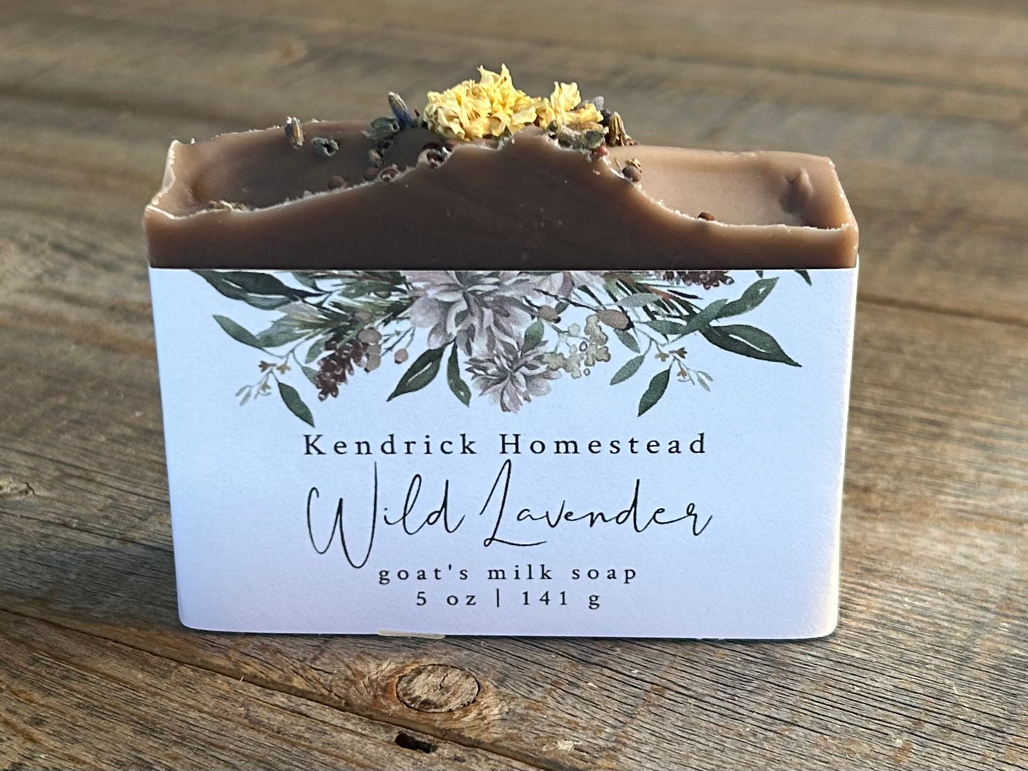 Take a step into the country with Wild Lavender soap. Scented with lavender, patchouli and juniper essential oil and sandalwood powder. It's the perfect blend of rich earthy floral.&nbsp; Made with nourishing goat's milk, olive oil, coconut oil, cocoa butter, avocado oil and castor oil. This soap is naturally colored with purple Brazilian clay and sandalwood powder for light exfoliation. Topped with lavender buds, broccoli seeds and a white chrysanthemum. Kendrick Homestead
