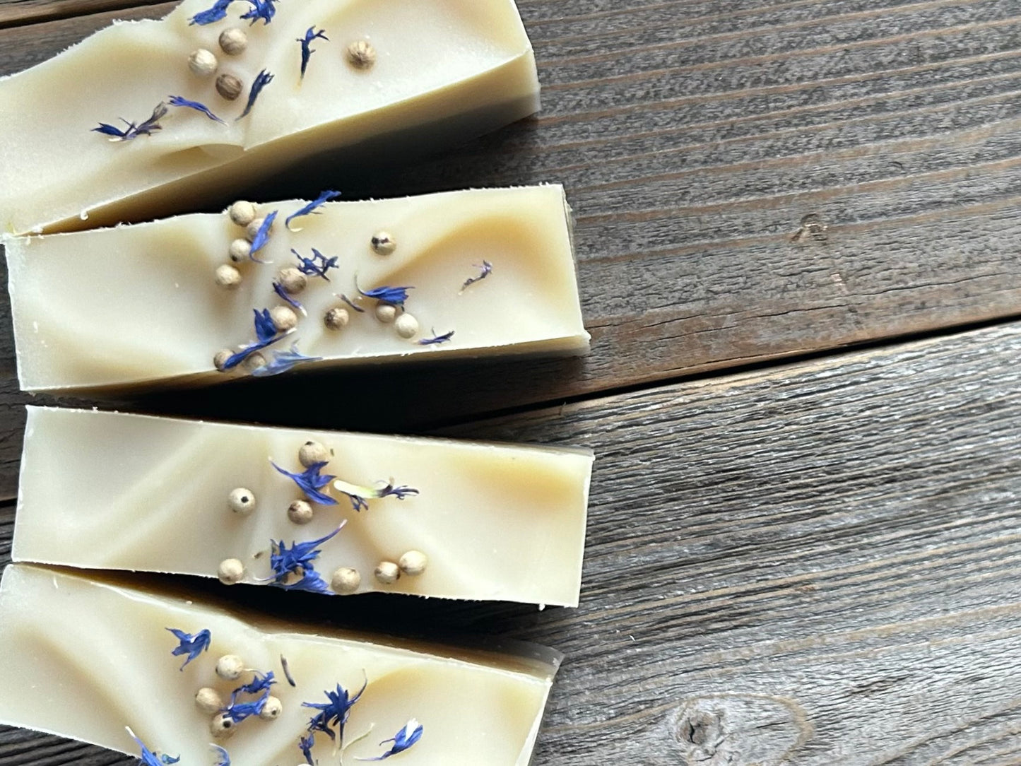 Seaside soap is made with coconut milk, olive oil, coconut oil, cocoa butter, avocado oil and castor oil with a relaxing smell of eucalyptus and spearmint essential oils. It is sprinkled with blue corn flowers and white peppercorns. Naturally colored with white kaolin clay and indigo powder. Kendrick Homestead.